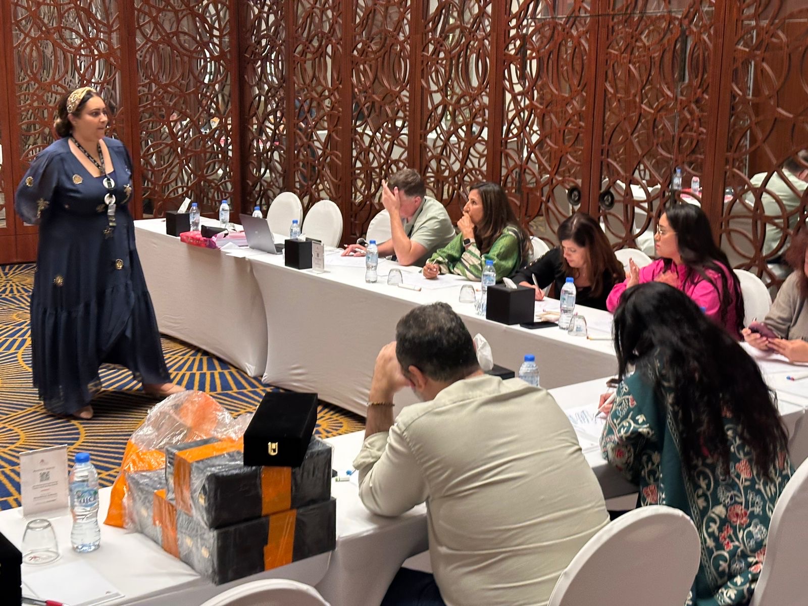 Nahla ElBanhawy running a session for an institutional group seated along a long table